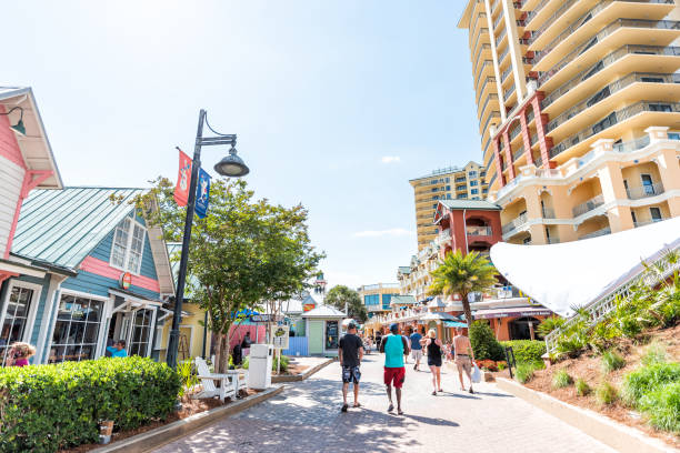 City town village Pirate's Alley on Harbor Boardwalk during sunny day in Florida panhandle gulf of mexico, tourists people walking Destin, USA - April 24, 2018: City town village Pirate's Alley on Harbor Boardwalk during sunny day in Florida panhandle gulf of mexico, tourists people walking harborwalk stock pictures, royalty-free photos & images