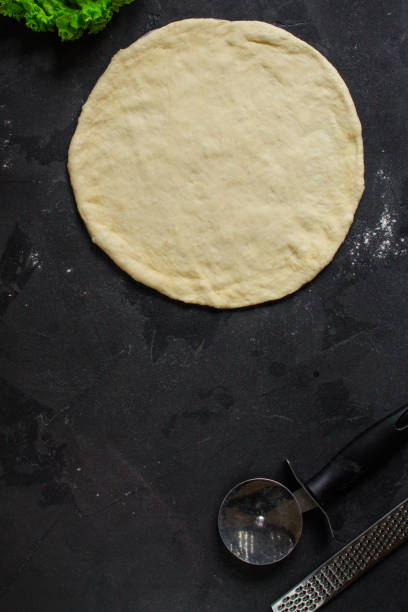 istock pizza - dough, preparation, flat cake (the process of cooking). Top view with copy space 1073308054