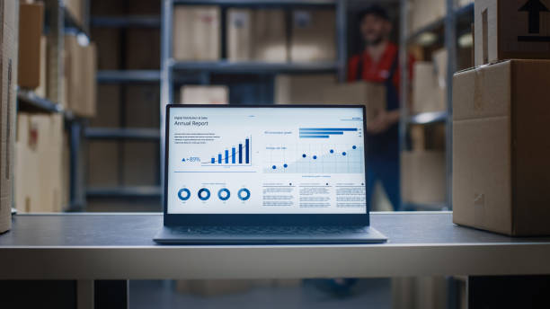 istock Laptop Screen with Infographics Displaying Graph and Statistics with Annual Results Growth Standing in Warehouse. 1073312082