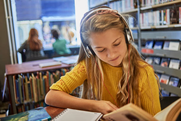 bambina che ascolta musica e studia - reading and writing classroom alphabet learning foto e immagini stock
