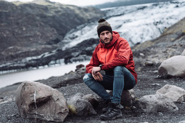 istock man sitting on a glacier in iceland 1073354036