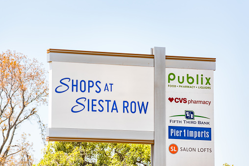 Sarasota, USA - April 28, 2018: Florida city during day with closeup of Strip Mall sign called Shops at Siesta Row with Publix grocery supermarket, CVS