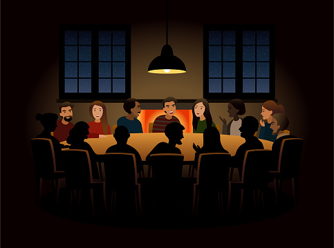 Group of people at a round table having a discussion with cozy atmosphere.