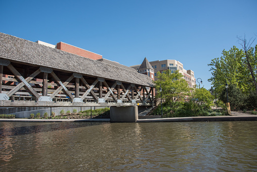 Naperville, Illinois, United States-May 6,2017: DuPage River, local architecture and covered footbridge on the Riverwalk​ in Naperville, Illinois