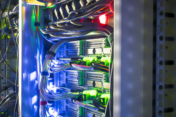 istock Modern server equipment works in a data center rack. Network interfaces and wires are in a dark server room. 1073414942