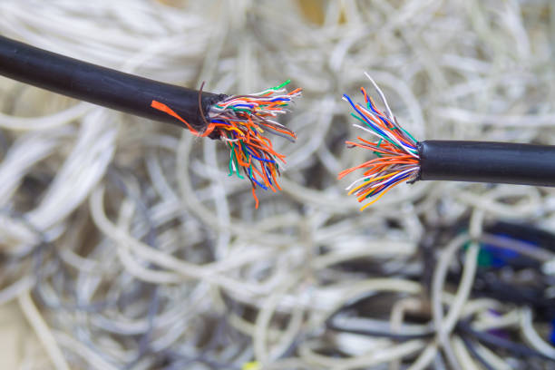 istock Breakdown of communication equipment. A damaged multi-core cable is shown close-up. Breakage of the telephone wire. Problems with telecommunications Internet connection. Disconnect. 1073415162