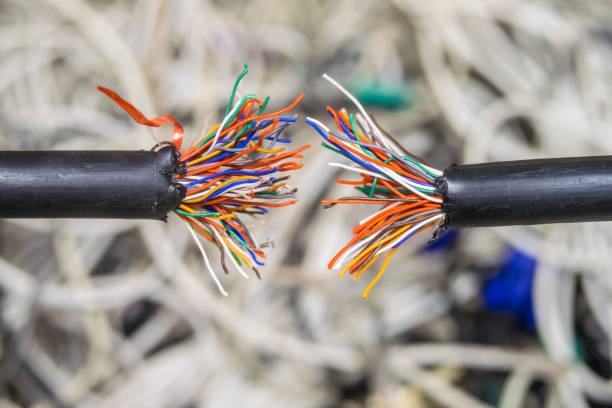 A damaged multi-core cable is shown close-up. Breakage of the telephone wire. Problems with telecommunications Internet connection. Disconnect