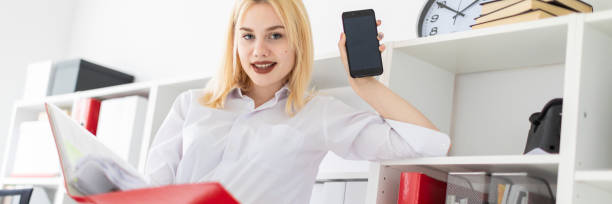 istock A young girl standing in the office and holding a folder. 1073415842
