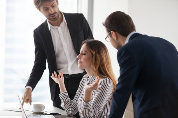 istock Young calm woman meditating in workplace, ignoring colleagues. 1073416032