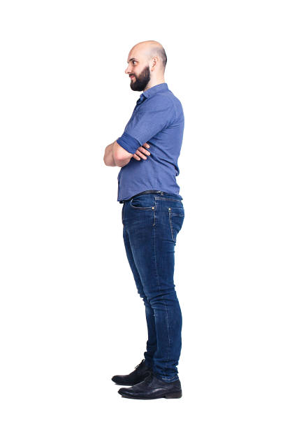 istock A young bearded guy stands sideways and looks away. Isolated on white. 1073416800