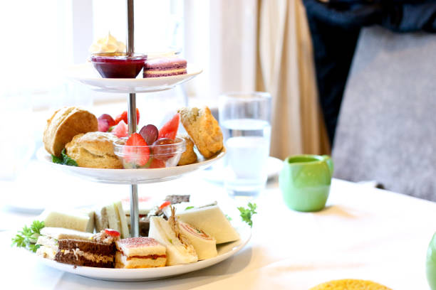 afternoon tea three tier stand of desserts, fresh fruits, pastries and sandwiches - afternoon tea imagens e fotografias de stock