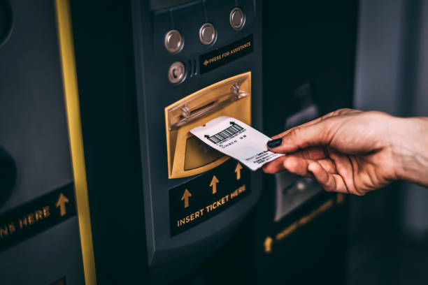 A close-up of a parking ticket being inserted into a ticket machine at a parking garage.