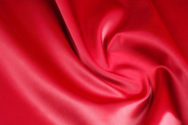 istock Texture, background, pattern. Red silk fabric.This satin fabric is perfect for making fabric flowers for use in hair accessories, jewery making, and fabric bouquets. 1073441228