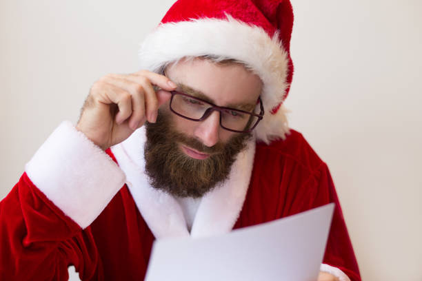 istock Focused guy wearing Santa costume and reading document 1073442764