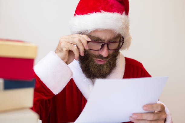 istock Focused man wearing Santa costume and reading document 1073442772