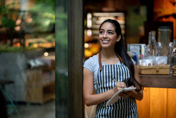 istock Beautiful waitress looking away daydreaming while holding a notepad and pen 1073458282
