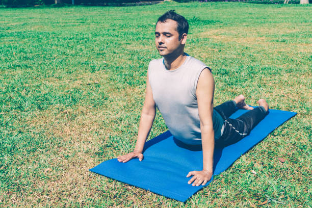 istock Indian man doing upward facing dog pose outdoors 1073460944