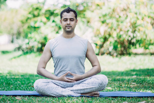istock Focused young Indian man meditating in lotus pose 1073460974