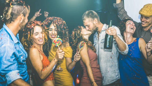 happy friends having multiracial fun at new year's eve celebration - young people drinking and dancing at after party in night club - friendship concept on drunk mood - focus on yellow cloth woman - celebration drunk drinking after party imagens e fotografias de stock