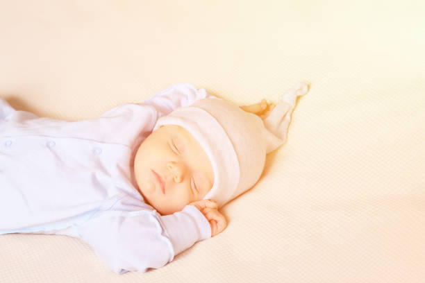 A swaddled newborn baby Boy is sleeping.\n