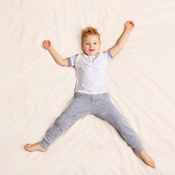 istock Funny boy lying on bed 1073525318