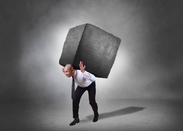 istock Businessman Carrying Heavy Stone 1073555436