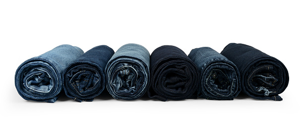 Rolled denim jeans with different shades on a white background