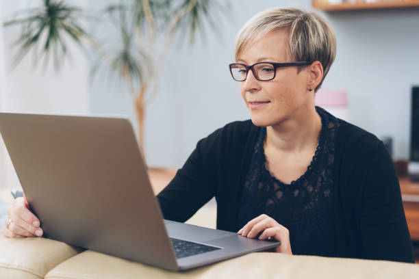 istock Middle-aged woman in glasses working on a laptop 1073560318