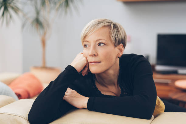 istock Attractive blond woman lost in thought 1073560418