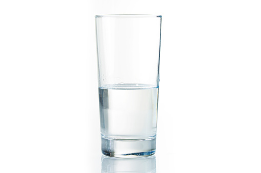 Half full water glass on white background