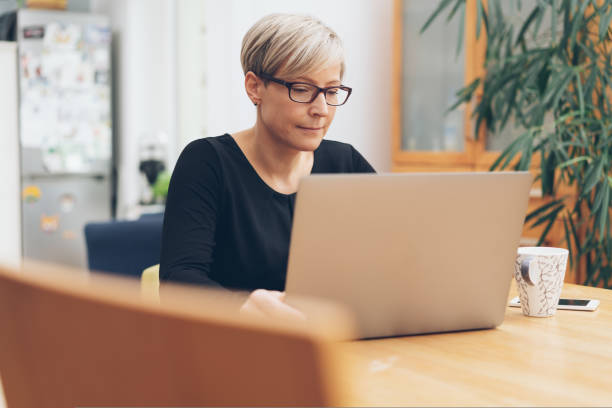 istock Middle aged woman working at laptop computer 1073563356