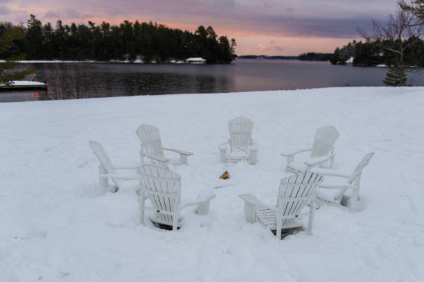 istock Adirondack chairs around a fire pit covered in snow 1073564900