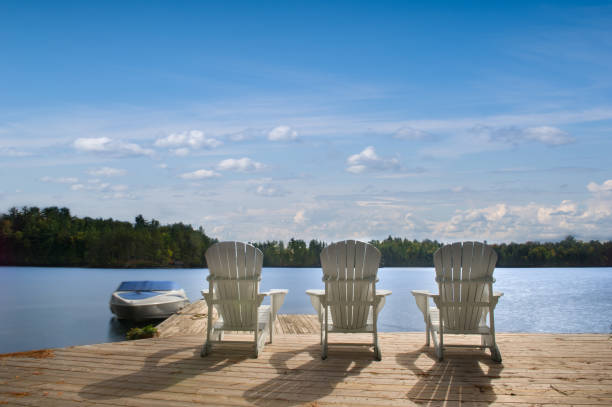 istock Muskoka chairs sitting on a wooden dock 1073567914
