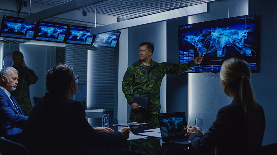 High-Ranking Military Man holds a Briefing to a Team of Government Agents and Politicians, Shows Satellite Surveillance Footage.