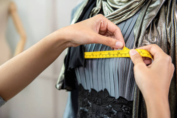 Muslim designer measuring size of dress with measurement tape Muslim designer measuring size of dress with measurement tape in tailor shop woman tailor stock pictures, royalty-free photos & images