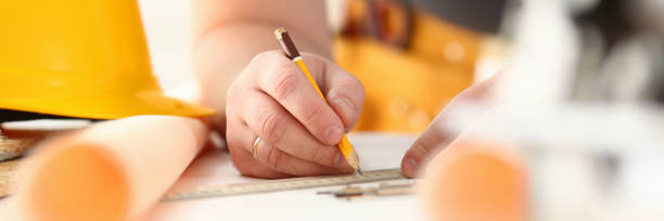 istock Arms of worker making structure plan on scaled paper closeup 1073611520