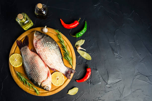istock fresh raw crucian fish with spices on wooden board 1073613092