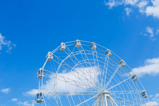 Ferris wheel against blue sky and clouds