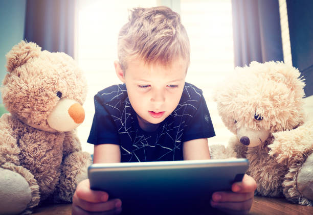 istock Boy and a teddy bears are watching a movie on a digital tablet 1073636730