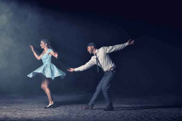 Couple dancing in the night. Couple dancing lindy hop at night in front of a spotlight. lindy hop stock pictures, royalty-free photos & images