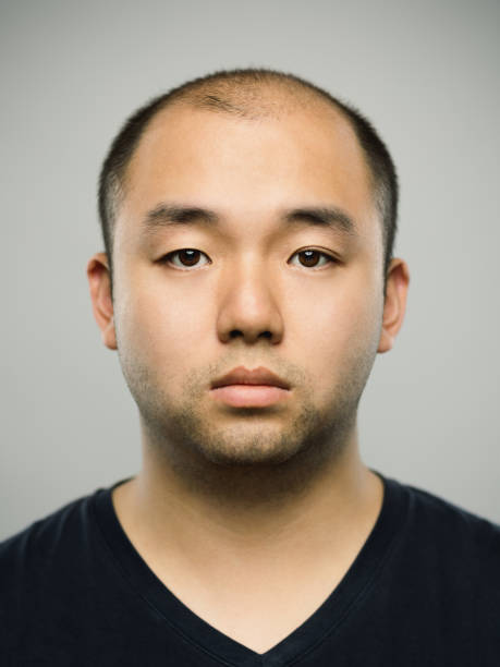 istock Real young adult chinese man with blank expression 1073644410