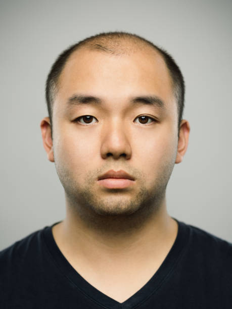 Real young adult chinese man with blank expression stock photo