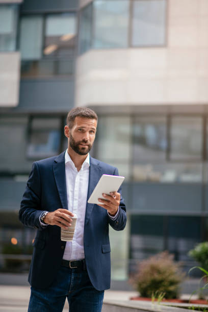 istock Handsome businessman working on a digital tablet 1073645684