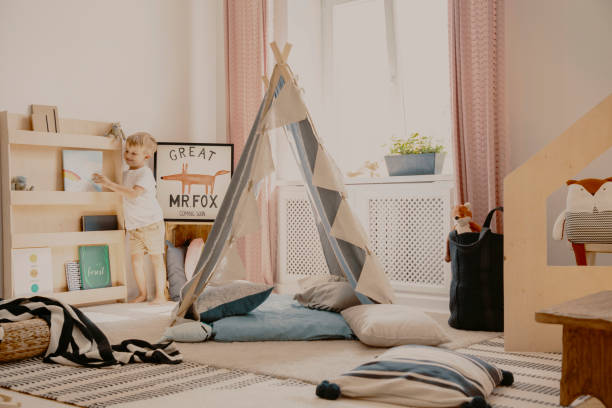 Scandinavian tent with pillows in the middle of stylish kids room in elegant apartment Scandinavian tent with pillows in the middle of stylish kids room in elegant apartment kids bedroom stock pictures, royalty-free photos & images