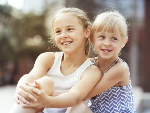 istock Two small happy sisters outdoors 1073651924
