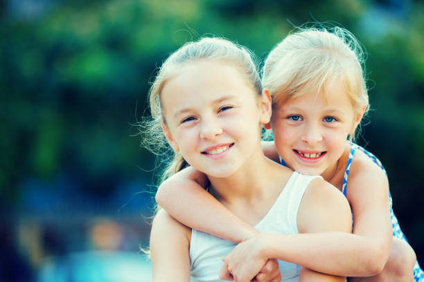 istock Two small happy sisters outdoors 1073651954