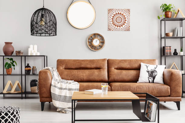 Warm ethno living room with big comfortable leather couch and metal furniture, real photo Warm ethno living room with big comfortable leather couch and metal furniture, real photo leather couch stock pictures, royalty-free photos & images