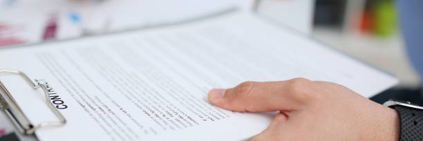 istock Female arm in suit offer contract form on clipboard pad 1073656242