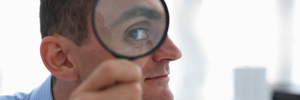 istock A businessman in blue shirt is holding a magnifying 1073656246