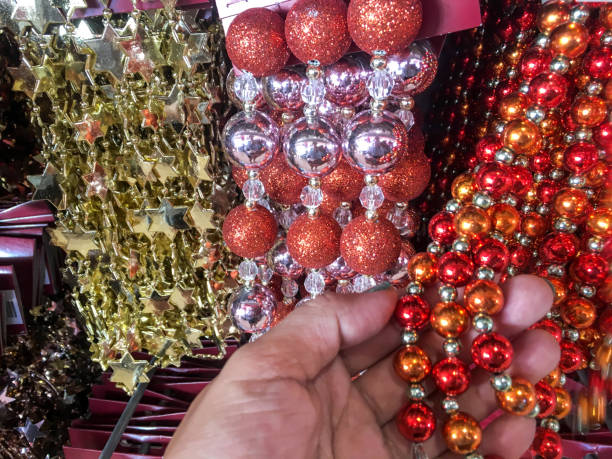 Close up females hand holding christmas decoration hanging beads chain garland